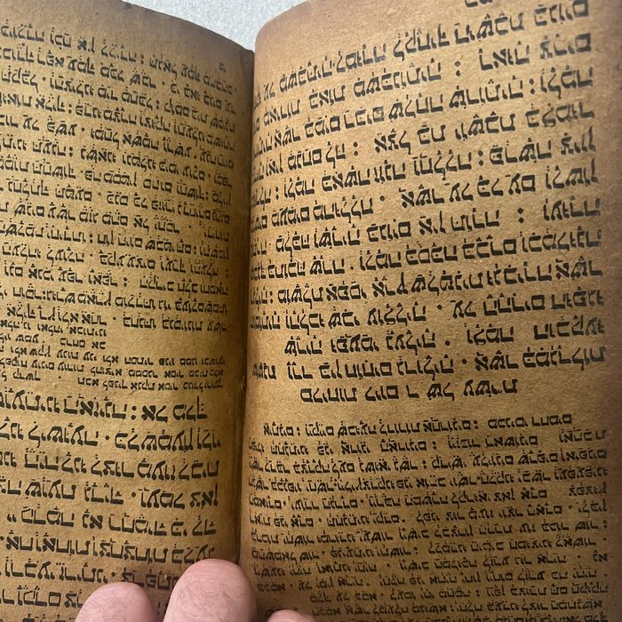 Dense hand-written right-to-left script in rounded connected letterforms on heavily browned paper