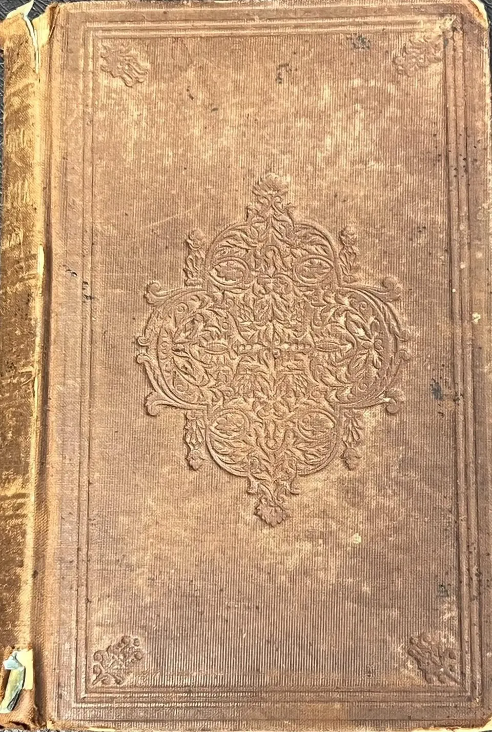 Worn brown cloth cover of an 1856 Ticknor and Fields printing of The Song of Hiawatha